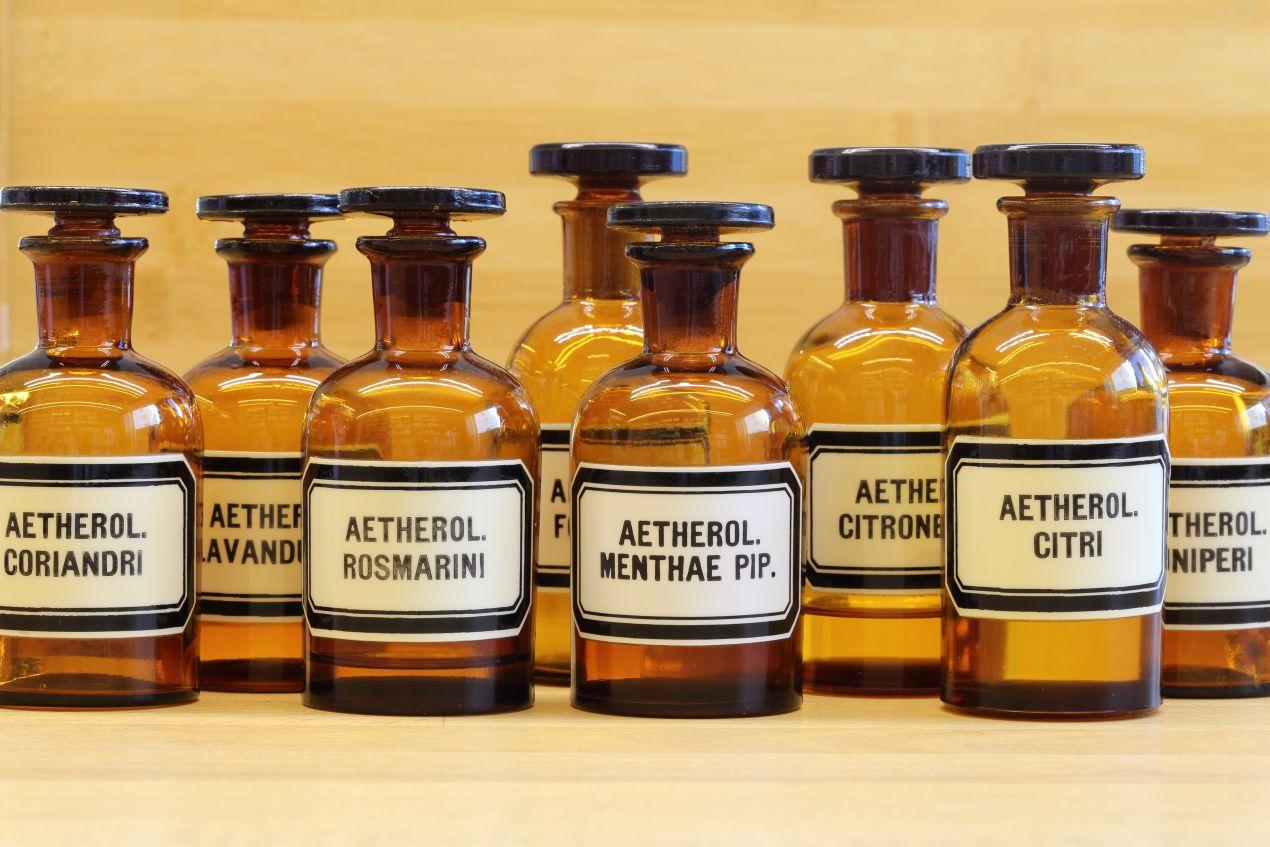 Mehrere Braunglasflaschen mit aetherischen Oelen wie Citri, Lavandula und Rosmarini zur umweltfreundlichen Methode, Ameisen zu bekaempfen